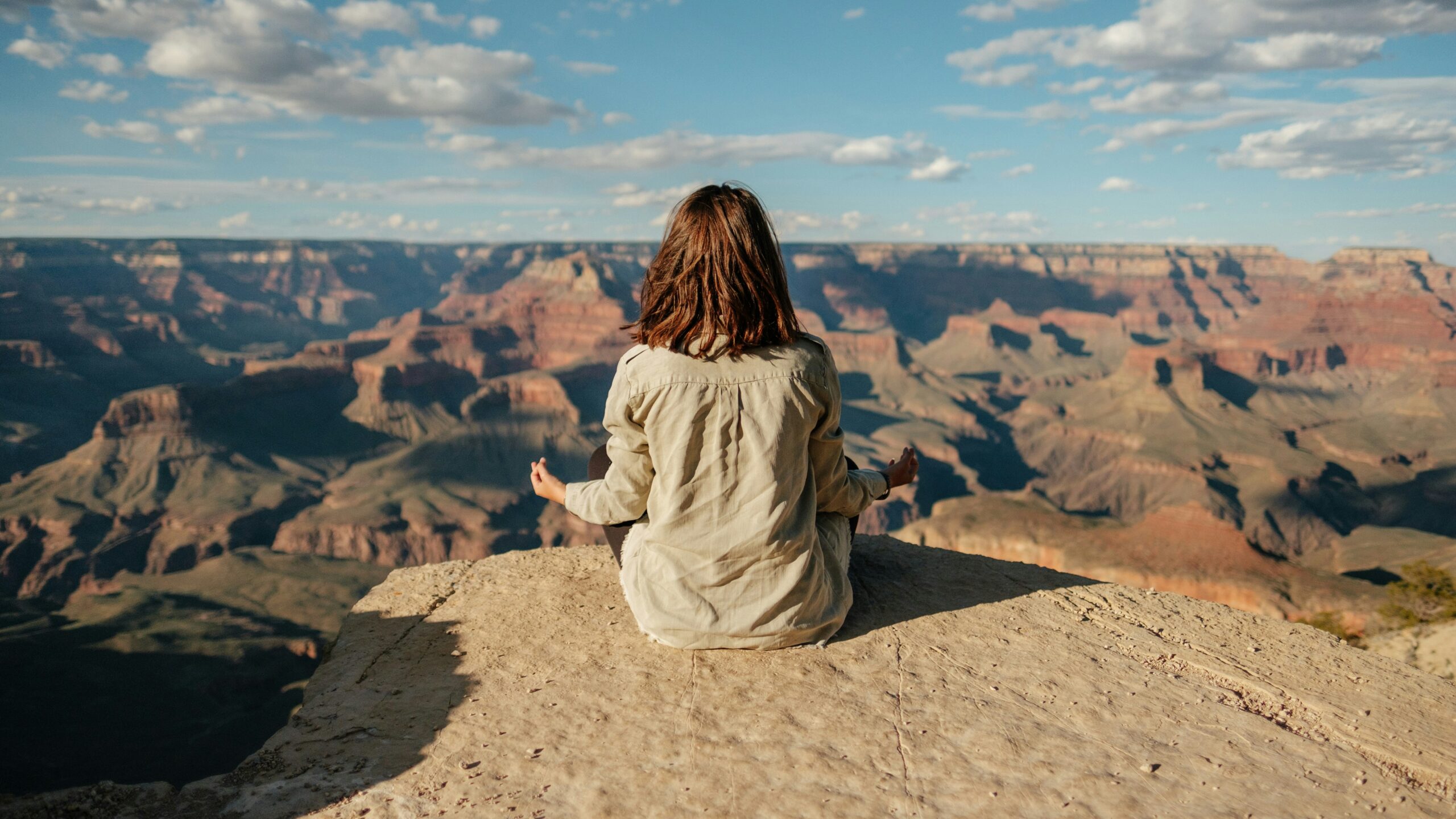 Mulher sentada na natureza após uma prática de Meditação & Movimento Consciente, num momento de tranquilidade e ligação ao corpo.